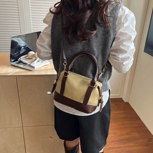 Sac oreiller en toile beige et cuir marron avec poignées porté par un mannequin