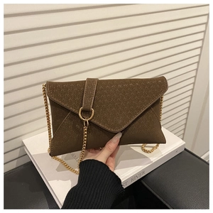 Detail of brown envelope shoulder bag with herringbone texture and gold chain strap