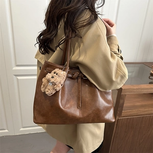 Brown leather tote bag for women with plush puppy charm and vintage wax texture