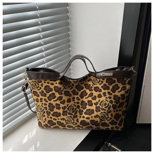 Macro view of leopard print tote bag featuring dark rose pattern and leather trim details