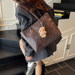 Vintage brown large capacity leather tote bag with plush bear charm on shoulder strap