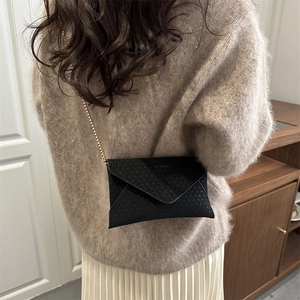 Minimalist black woven envelope crossbody bag with a delicate metal chain strap
