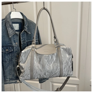 Close-up of silver textured fabric and grey leather details on a large tote bag