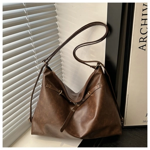Detailed view of vintage dark brown faux leather tote with metallic buckle and shadow effect