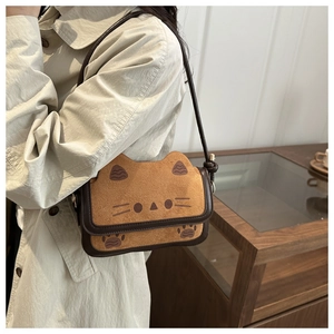 Close-up of cute brown cat-shaped crossbody bag with soft suede texture and cat ear detail