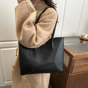 Chic black faux leather tote bag with geometric stitching and gold lettering for women