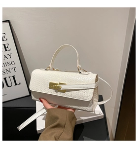 Détail de la texture tressée blanche avec fermoir doré tournant et poignée chic