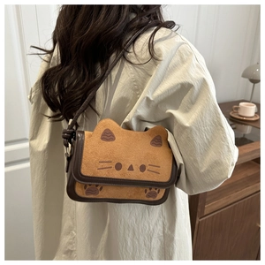 Detail of cute cat shaped crossbody bag showing warm brown texture and ear design