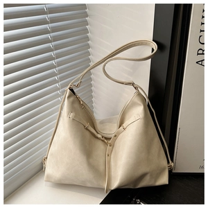 Detailed close-up of cream-white Hobo tote bag with golden hardware and soft leather pleats