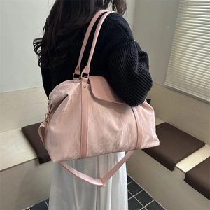 Pink large capacity travel bag with pleated texture shown in a lifestyle indoor setting