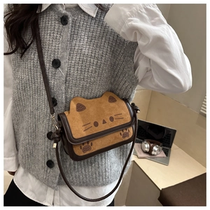 Detail of cute cat-themed shoulder bag with suede material and knotted strap detail