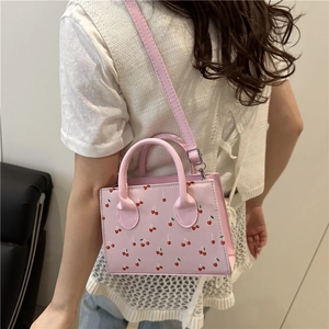 Sac bandoulière rectangulaire rose avec imprimé cerises et détails métalliques argentés