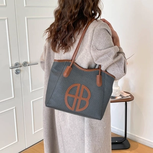 Minimalist large capacity woven tote bag with brown leather handles and classic logo