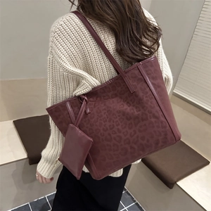 Burgundy faux leather tote bag with leopard texture shown on model in a modern style
