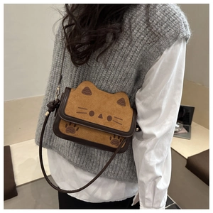 Detail of a brown cat-themed crossbody bag with cute ear shape and paw print details