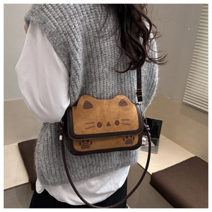 Detail of cute cat shaped crossbody bag in brown suede with adjustable strap