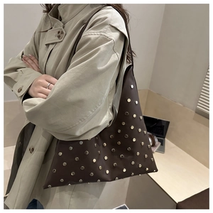 Vue détaillée du sac sous l'aisselle triangulaire avec rivets décoratifs et cuir mat