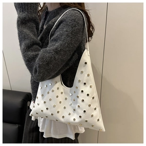Détail du sac sous le bras en cuir blanc avec forme géométrique et clous dorés