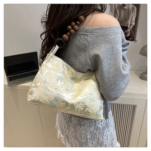 Detail of silk jacquard armpit bag featuring traditional Chinese garden motif and wooden beads