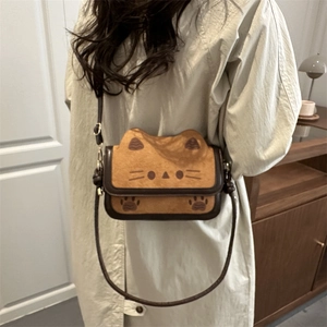 Cute brown cat-shaped crossbody bag with 3D ears and paw print detail worn by a model