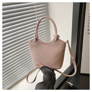 Detail showing pink cartoon relief texture on leather crossbody bucket bag