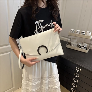 Minimalist white envelope clutch bag with black hardware and detachable wrist strap