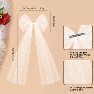 Detail of white tulle bridal bow hair clip with Bride to Be embroidery and pearls
