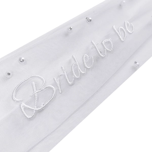 Detail of white bridal veil hair clip with Bride to be embroidery and pearl beads