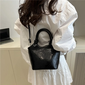 Minimalist black embossed bucket bag with cartoon patterns and top handles