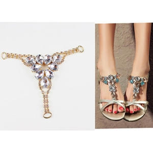 Detail of T-shaped rhinestone shoe charm accessory with crystals on gold-tone metal base
