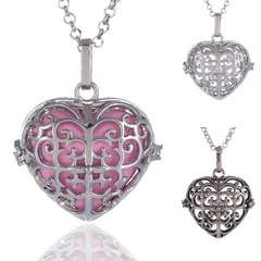 Detailed macro view of the silver hollowed-out heart pendant necklace with pink core