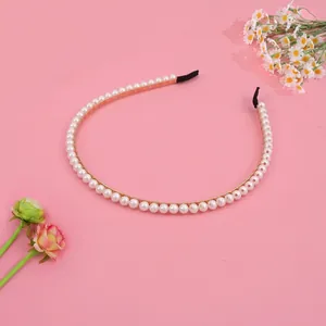 Elegant pearl headband with white beads on a gold metal frame for a French chic style