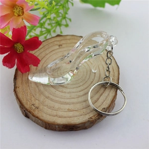 Close-up of crystal high heel shoe keychain on rustic wood with floral accents