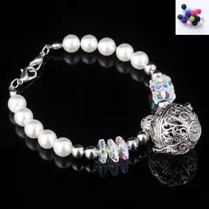 Detalle de pulsera nupcial de lujo con perlas blancas, cristales y un colgante de flores