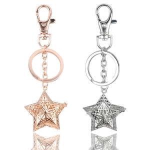 Detailed view of star-shaped hollow metal keychains in rose gold and silver finishes