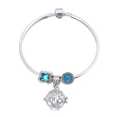 Primer plano detallado de una pulsera de dijes plateada con colgantes de piedras azules