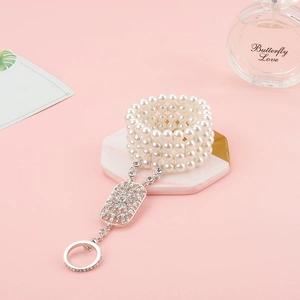 Detail of multi-layer pearl slave bracelet with crystal ring on marble tray