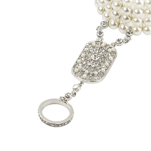 Macro detail of Gatsby style pearl hand chain with crystal floral center and silver ring