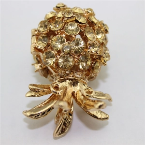 Macro shot of gold pineapple keychain with yellow crystals and openwork leaf details