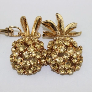 Close-up of golden pineapple keychain with sparkling yellow and white crystal rhinestones