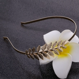Elegant gold leaf headband crown with intricate metal textures for bridal wedding hair style