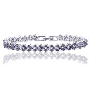 Detalle de pulsera de lujo con cristal púrpura, flores plateadas y cierre plegable