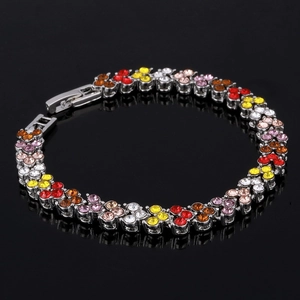 Vue détaillée d'un bracelet argenté orné de cristaux multicolores sur fond noir brillant