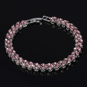 Détail du bracelet avec fleurs en cristal rose et monture argentée sur miroir noir