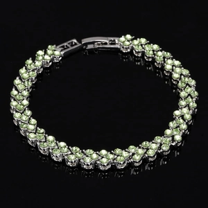 Détail macro d'un bracelet fleuri argenté serti de cristaux vert clair avec fermoir à rabat