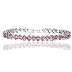 Detalle de la pulsera plateada con pedrería rosa y cierre desplegable seguro