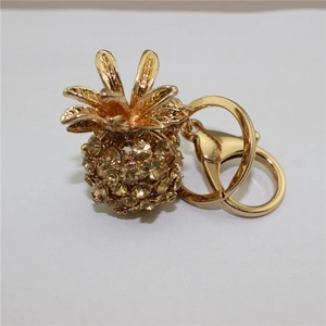 Detailed view of a gold-tone pineapple keychain with sparkling yellow crystal inlays