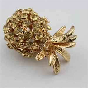 Detailed close-up of gold-plated pineapple keychain with sparkling yellow crystals