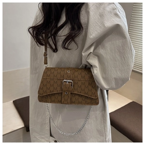 Detail of a brown leather crossbody bag with M-pattern print and silver chain strap