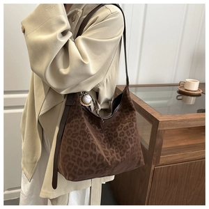Detail of leopard print tote bag with suede texture and a small baseball charm